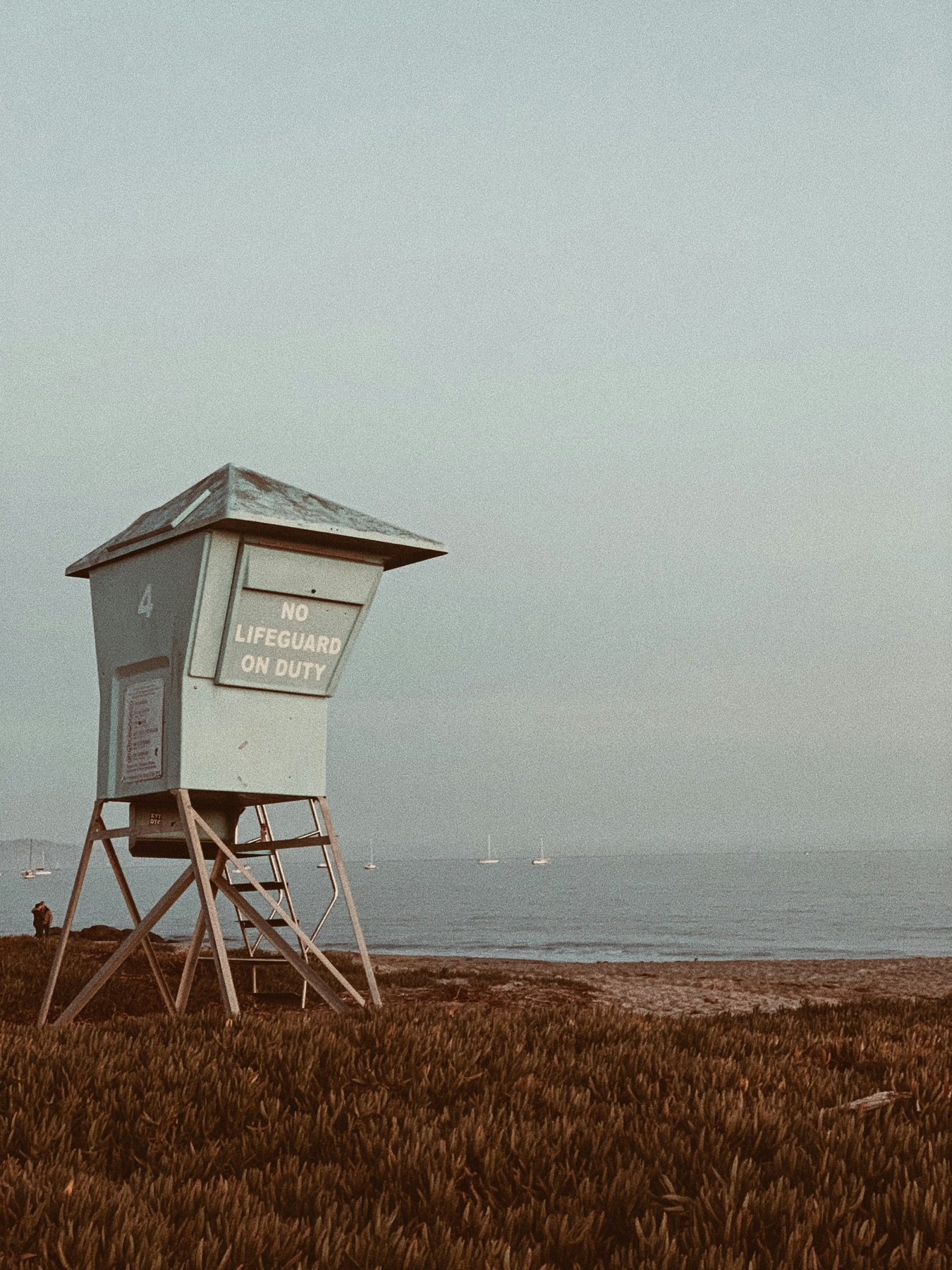 A lifeguard tower overlooking sailboats on the Mesa's coastline