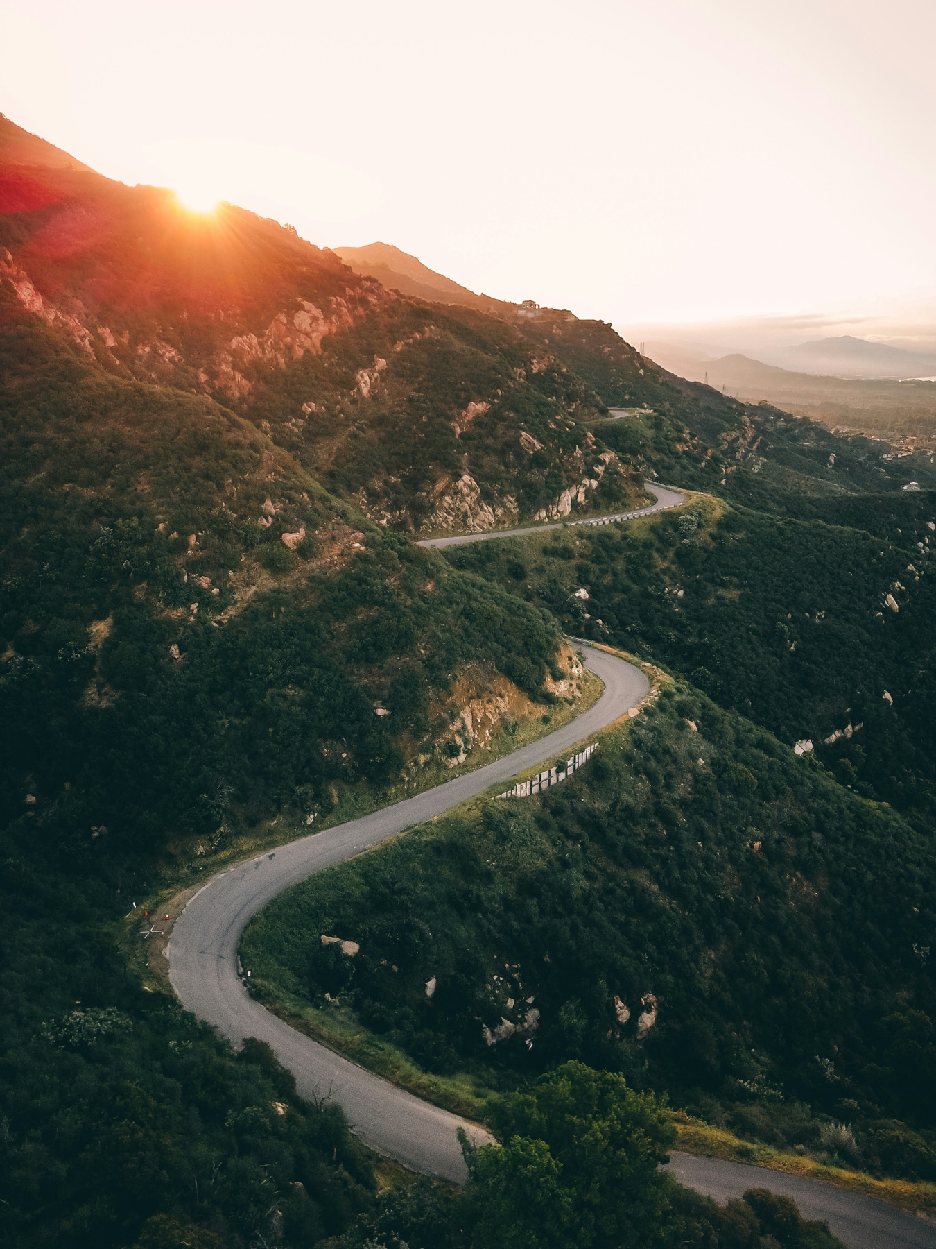 The winding San Marcos Pass road descending toward the Santa Ynez Valley at sunset