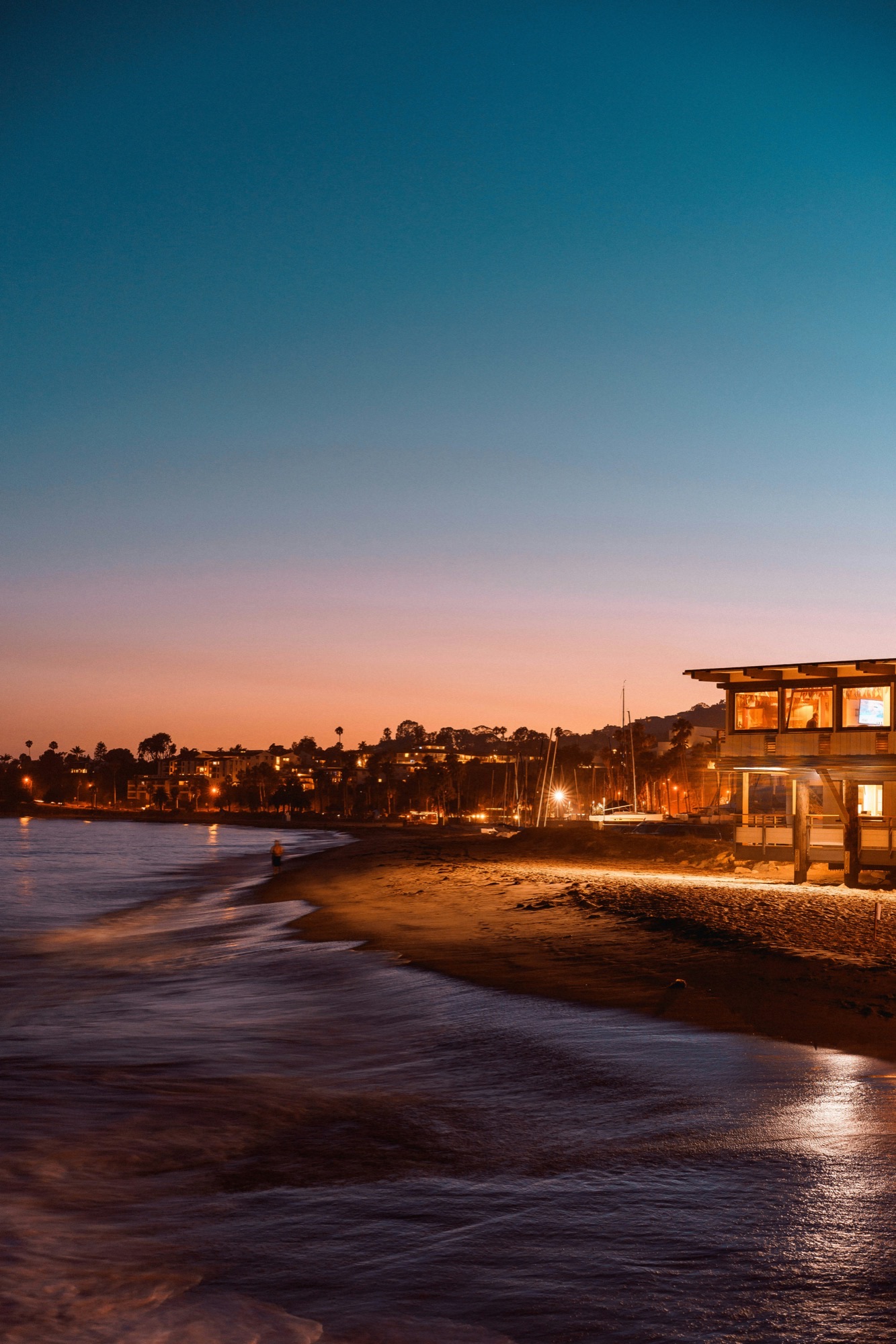 A warmly lit Santa Barbara home along the coast at dusk